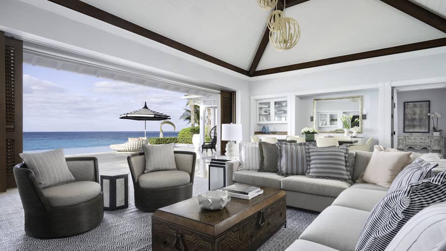 Beachfront Villa Residence large living room with modular sofa, armchairs by open wall to patio overlooking ocean  