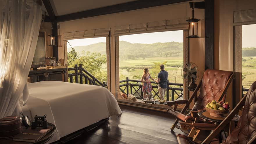 Couple enjoys cocktails overlooking fields and mountains