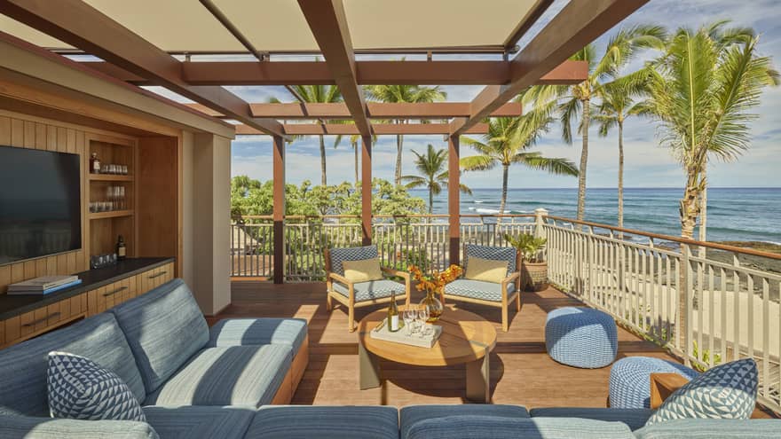 Private patio with light blue cushioned sofa, TV, table, ocean view