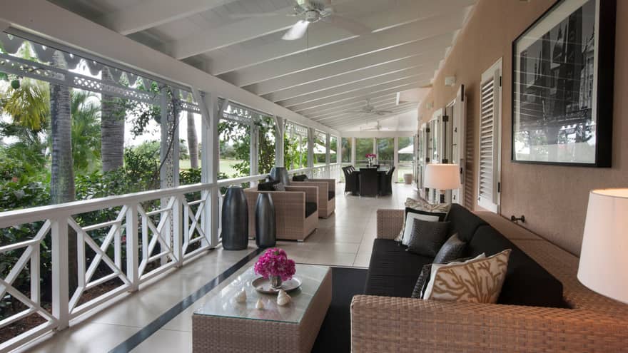 Residence Villa wicker patio sofa, table under covered porch with white trim