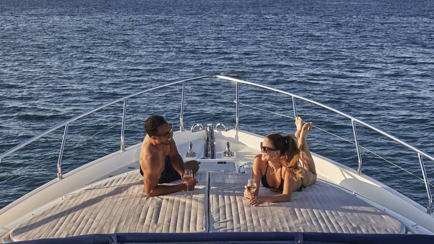 Man and woman lay on front of yacht
