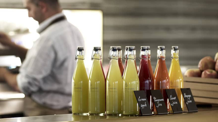 Several pressed juices sealed in glass jars on a countertop. 