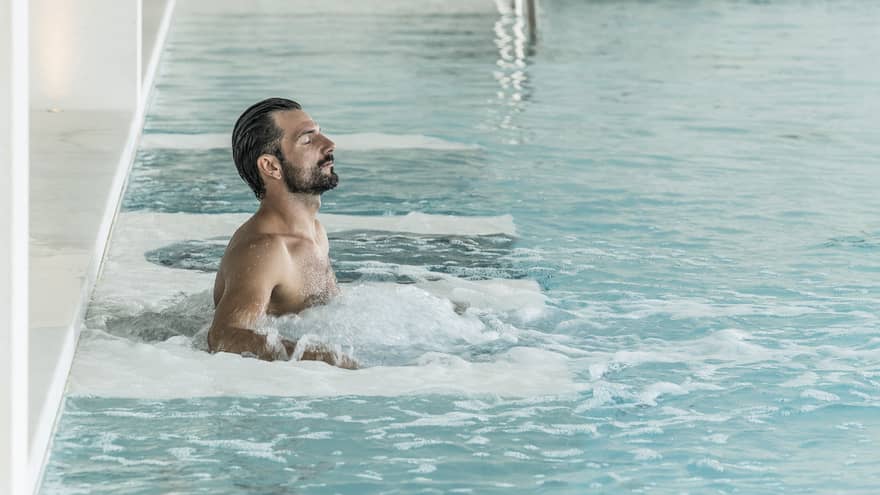 Man relaxes in luxury hotel pool