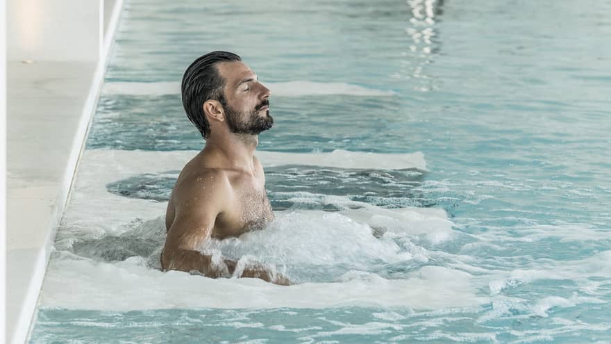 Man relaxes in luxury hotel pool