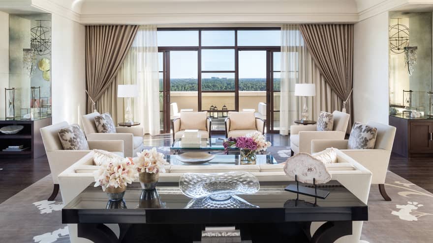 Large black console table with vases, fresh flowers in front of seating area with white sofas