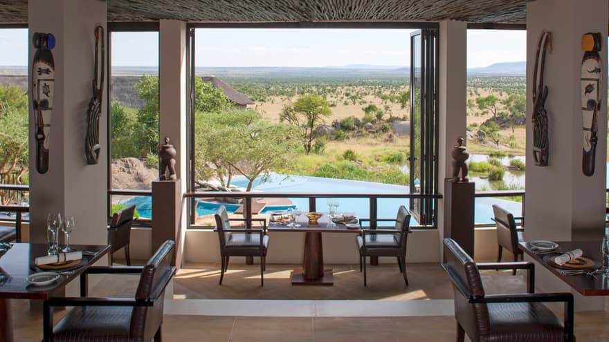 Indoor dining room with Indigenous art, looking down over swimming pool, fields