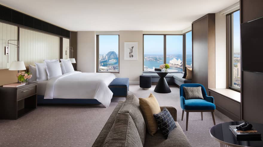 A cozy bedroom with subtle bursts of colourful decor, overlooking the iconic Sydney Harbour
