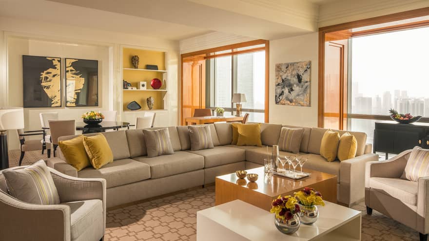 Four Seasons Suite long sofa sectional with yellow pillows, tables, large picture windows