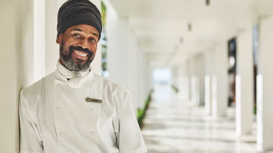 Close-up of smiling chef in white jacket outdoors on sunny day