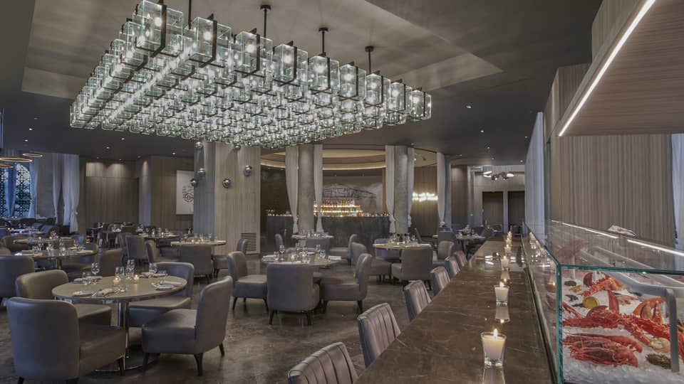 Bullona dining area and seafood counter with low lighting and marbled floors