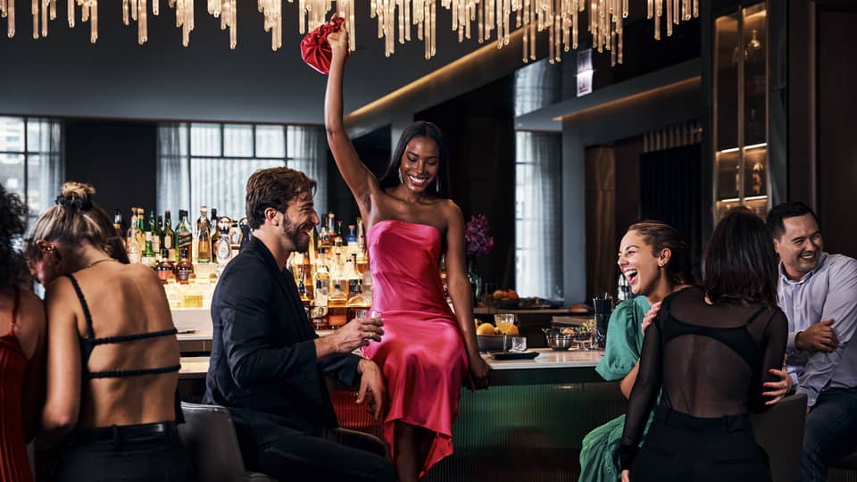 A group of people relaxing and talking at a bar.