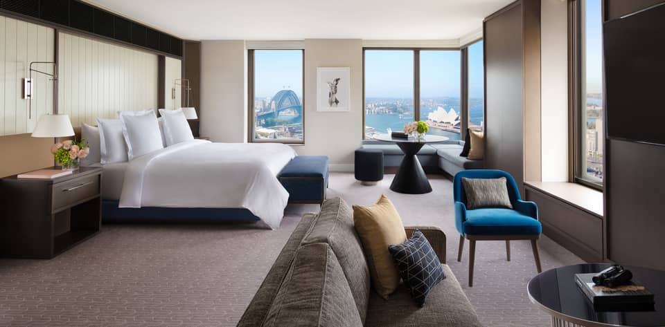 A cozy bedroom with subtle bursts of colourful decor, overlooking the iconic Sydney Harbour
