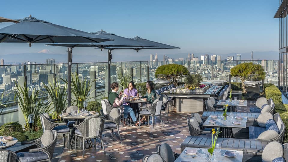 Group of three friends enjoy a meal on PIGNETO's open-air terrace