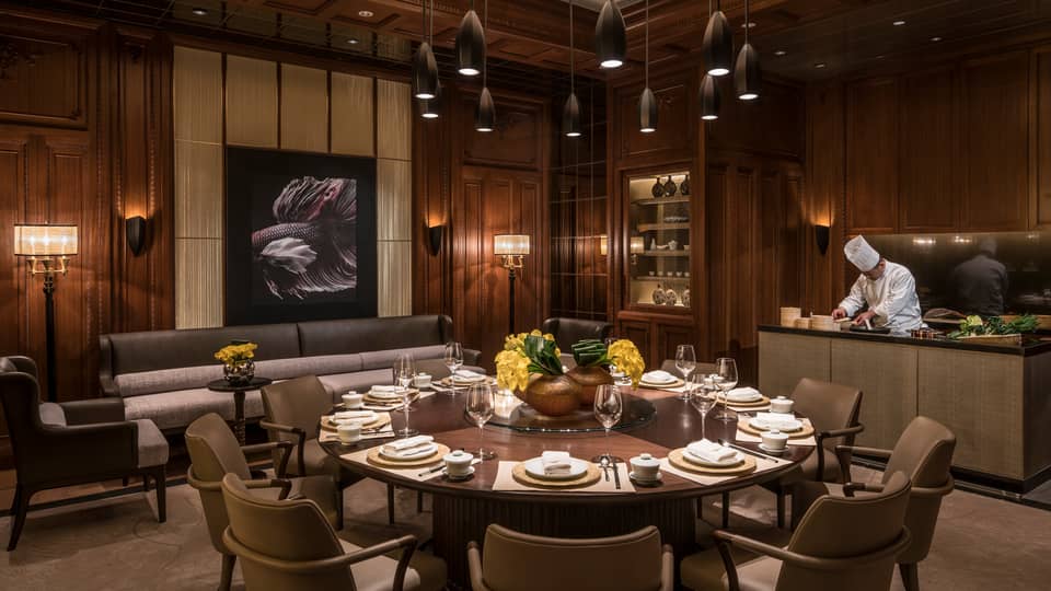 JIN restaurant, chef prepares food behind large round 12-seat table