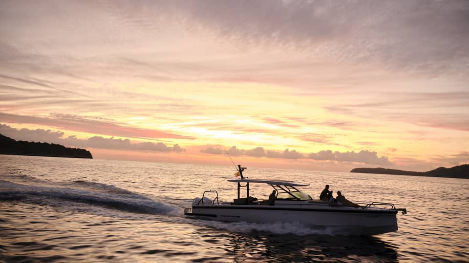 A boat on the water at sunset in island destination