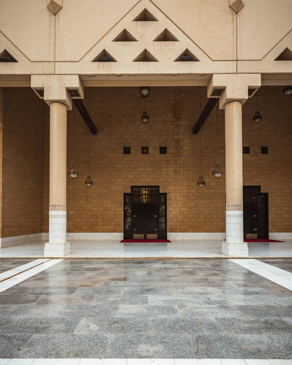 A brown stone wall with grey tile flooring.