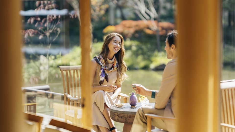 Smiling couple enjoys romantic dinner at Fuju's Shakusui-en pond garden
