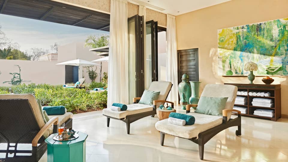 Lounge chairs with rolled towels in large open-air sunny spa patio