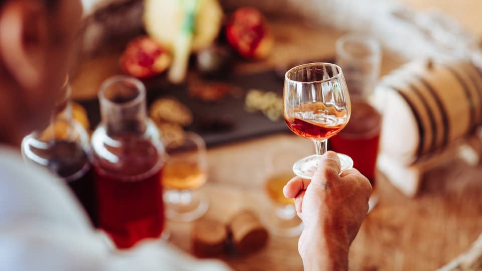 A person holding a clear glass of rum 