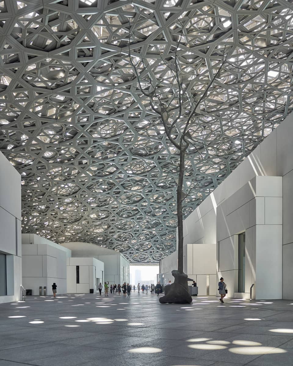 A large sculpture inside of a white stone building.