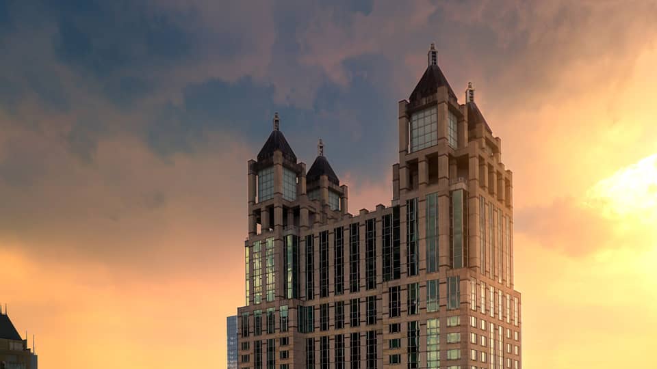 A tall building with a sunrise behind it.