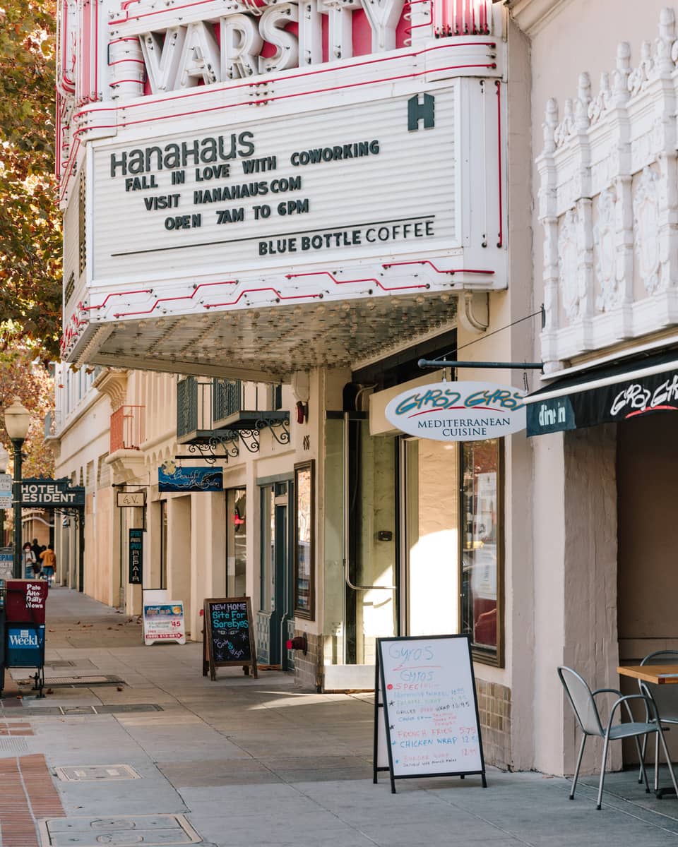 Shops along a sidewalk with signs at each door.