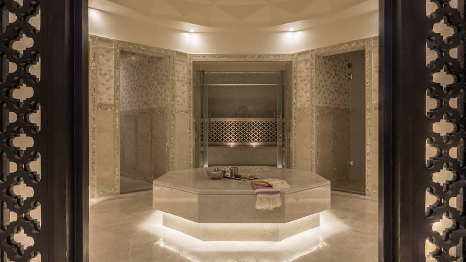 Hammam room with illuminated under lighting, beige marble