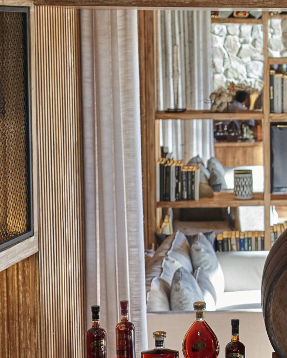 A bartender smiles as four guests sample different kinds of rum at a table set with bowls of chocolate, glasses and bottles.