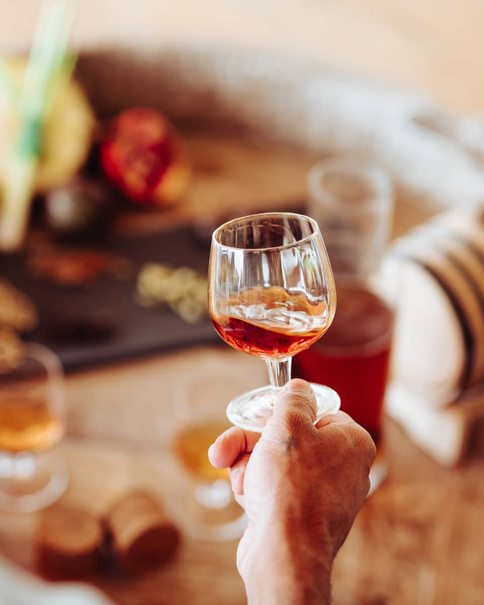 A person holding a clear glass of rum 