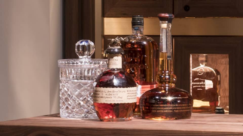 Various whiskey, bourbon, crystal bottles on bar