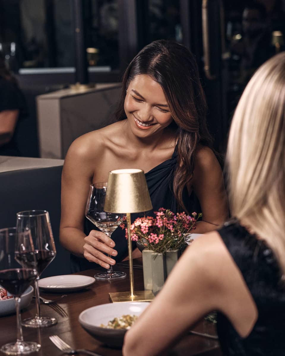 Three guests sitting at a dining table while talking and laughing.