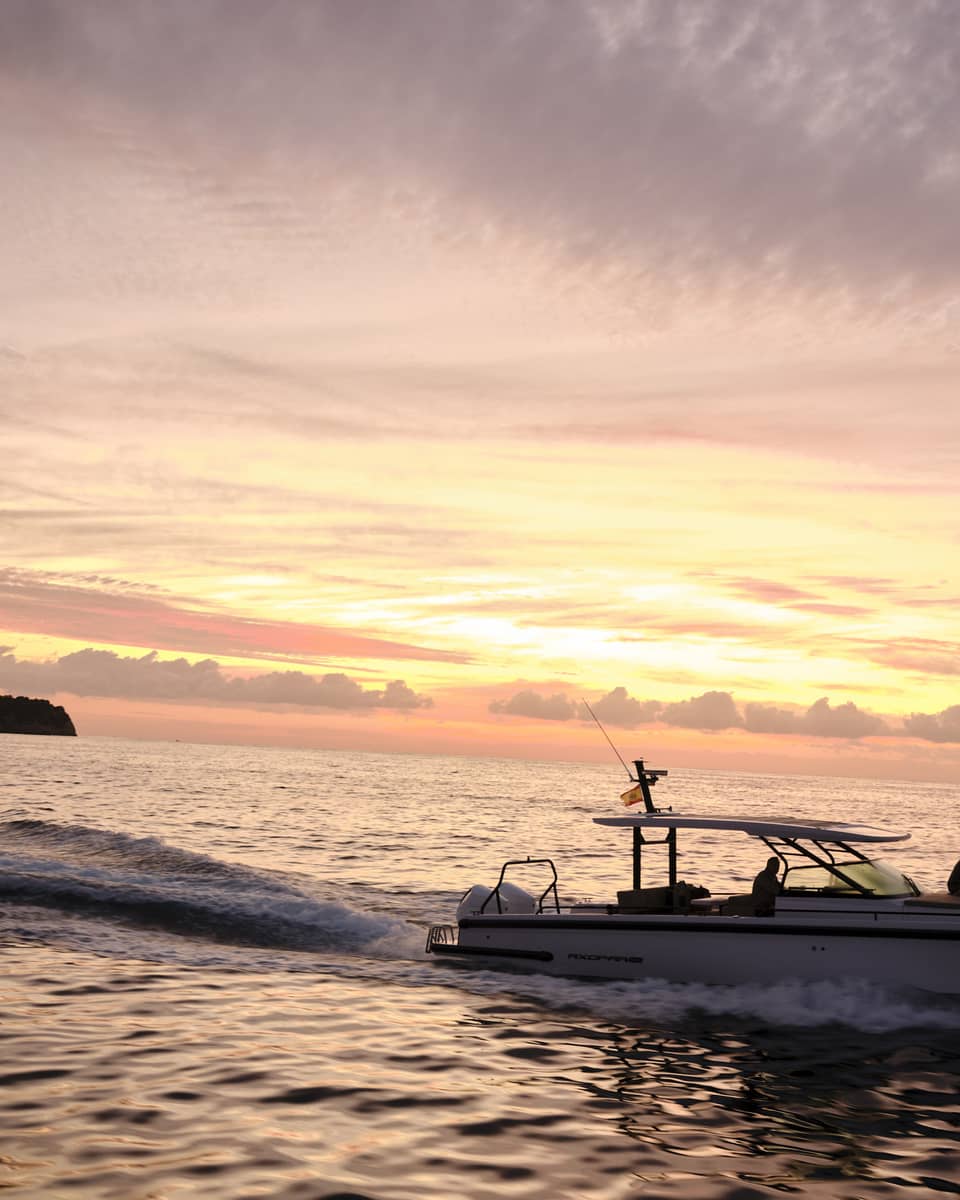 A boat on the water at sunset in island destination