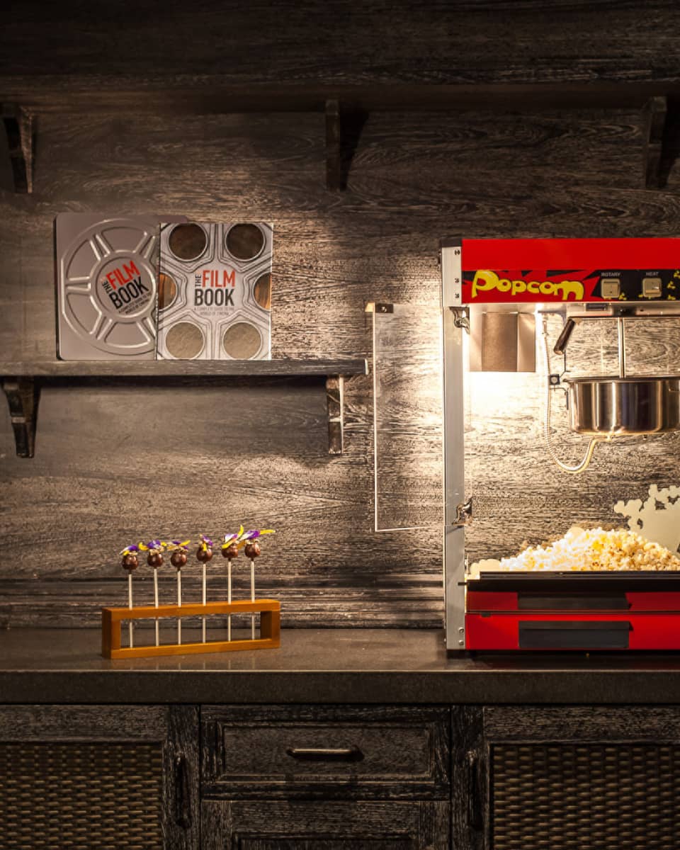 Popcorn machine, candy and film books on shelf in dark room