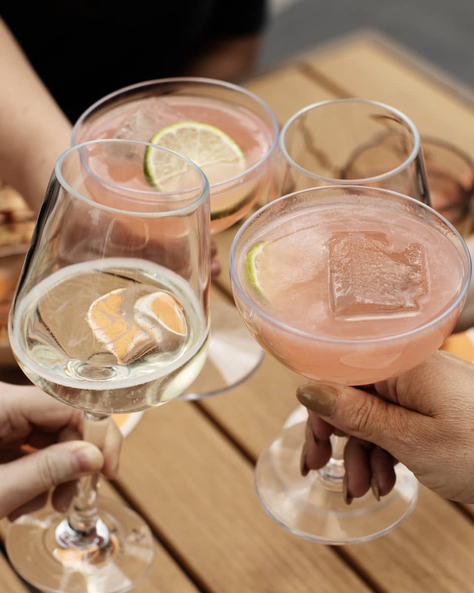 A group of people toasting with wine and cocktails.