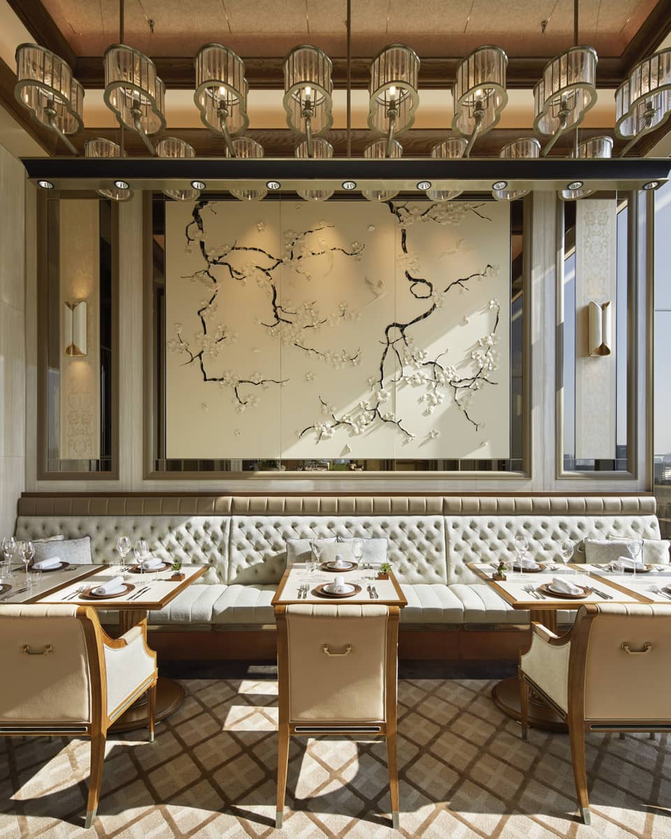 Est dining room with tables for two, muted cream decor, natural light, view of the city 