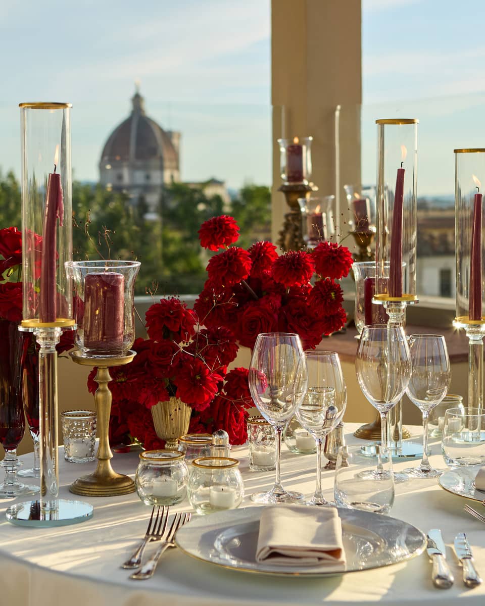 Terrace with elegant, romantic table set for two with crystal glassware and candlesticks looking out to the Duomo