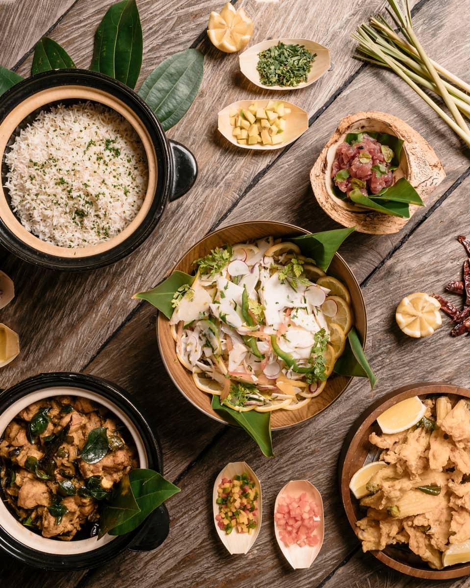 Aerial view of rustic wood table with bowls of gourmet rice, salads and entrees 