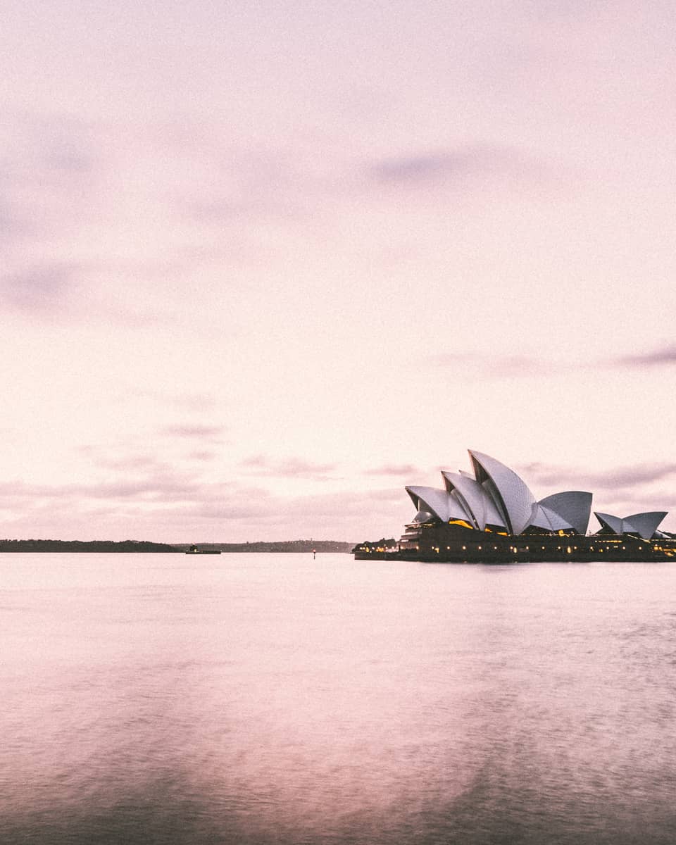 Sydney Harbour's iconic Opera House building on water, pink hue
