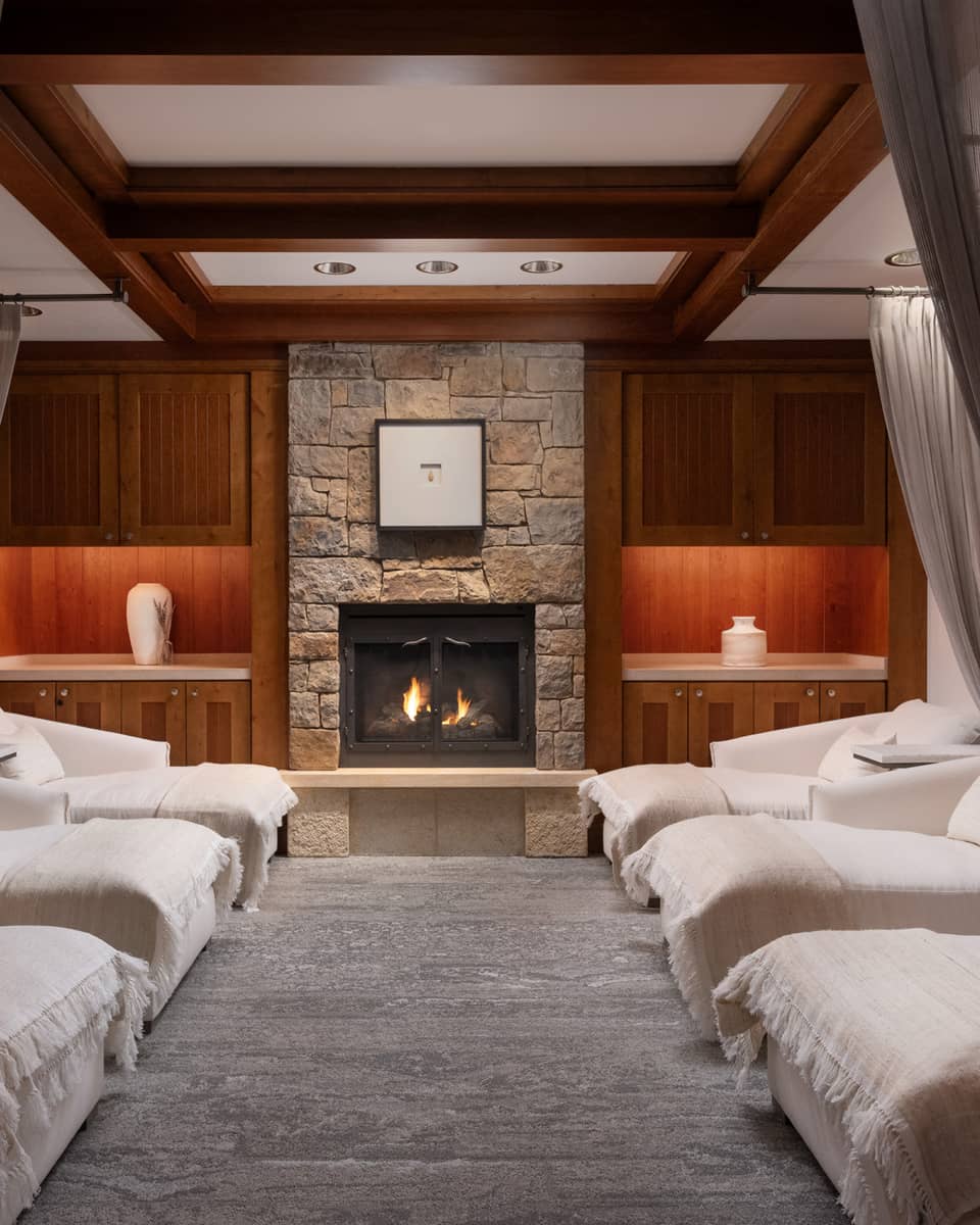 Lounge with spa beds, a fireplace and grey curtains.