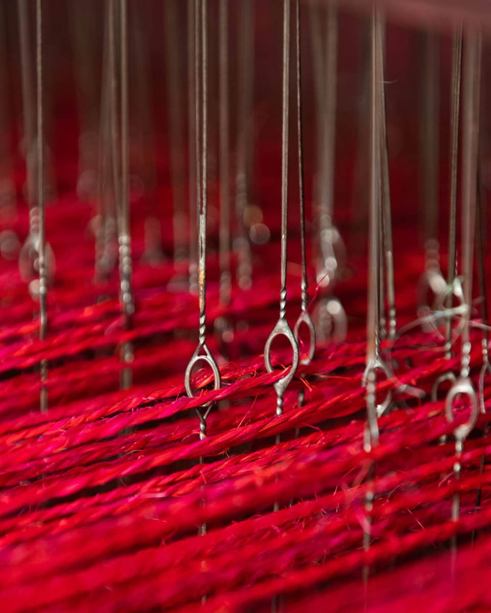 Long pieces of red string suspended by a series of wire.