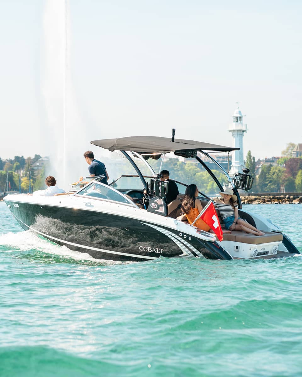 Group of friends in motorboat on Lake Geneva near the Jet d'Eau fountain