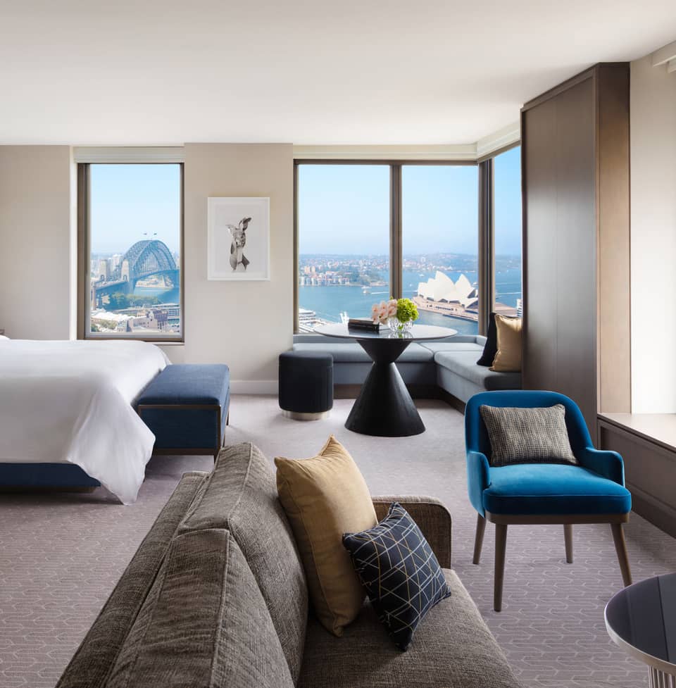 A cozy bedroom with subtle bursts of colourful decor, overlooking the iconic Sydney Harbour