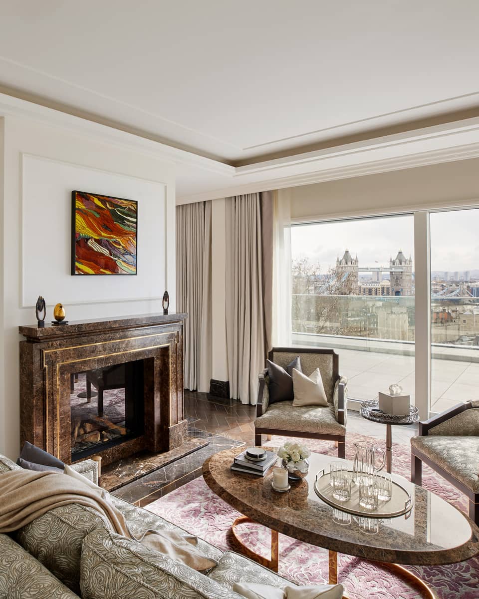 Elegant residence living room with fireplace and tall windows with river views