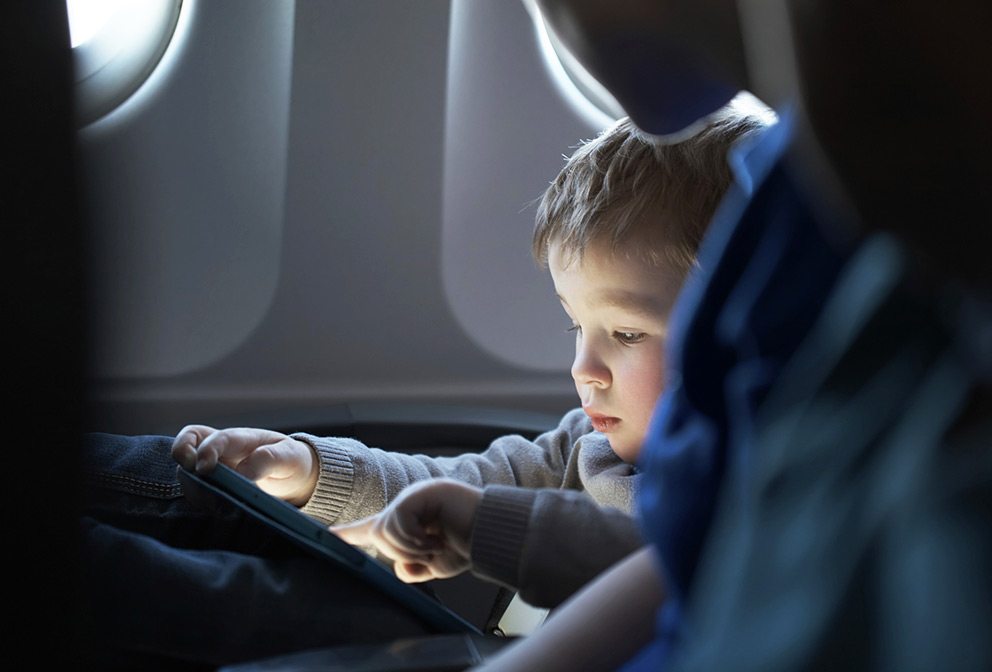 Toddler travelling on airplane watching iPad