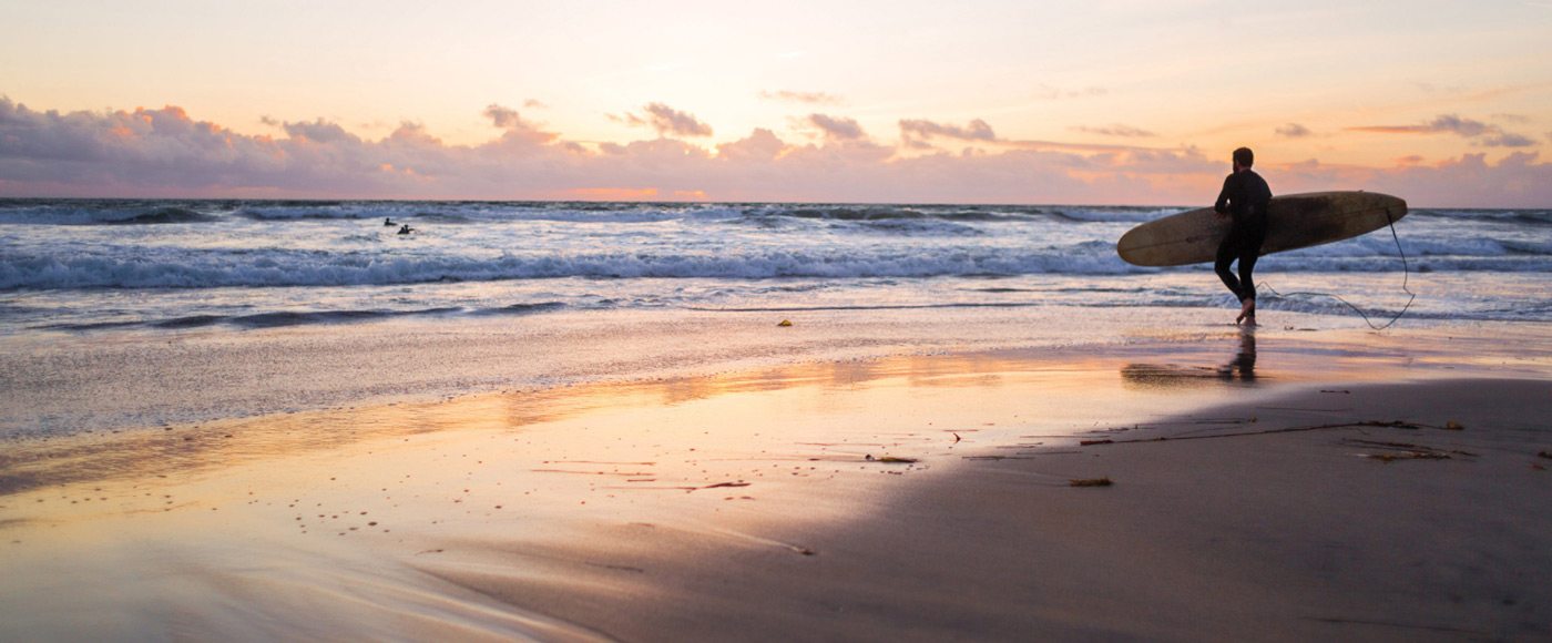 A surfer on the beach in San Diego