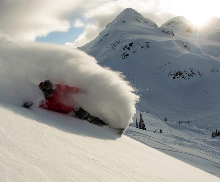 A snowboarder going down a mountain