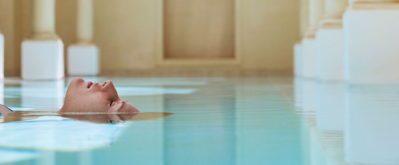 A woman enjoys the water at a public bath.