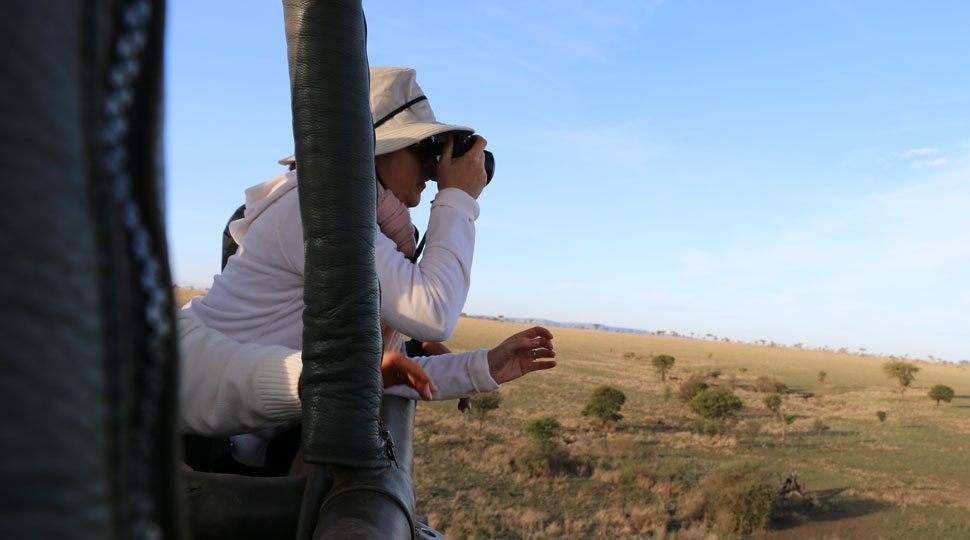 Passenger takes photo on hot air balloon tour in Serengeti