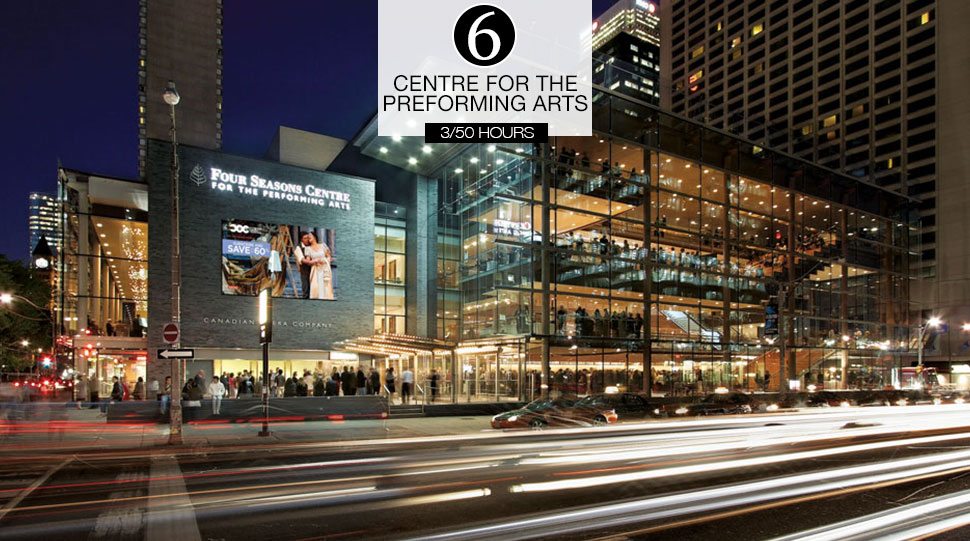 Cars drive by the Four Seasons Centre for the Performing Arts at night.