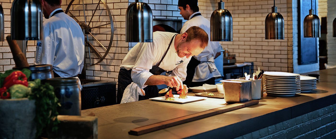 Chef Zack Mills prepares a dish in the kitchen of Four Seasons Balitmore.